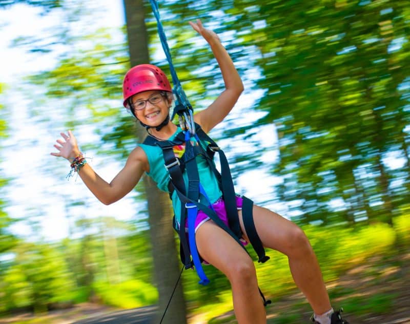 Girl zip lining without using her hands